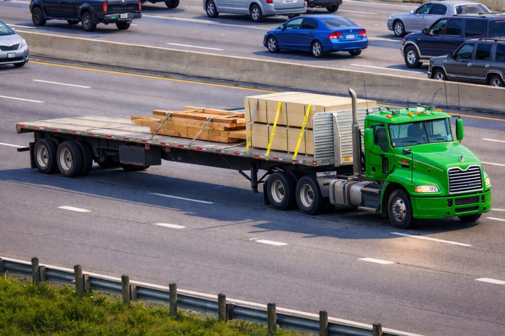 green semi truck flatbed lumber highway vivid light