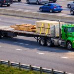green semi truck flatbed lumber highway vivid light