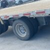 Rear axle wheels and tires beneath the aluminum deck of the 2023 Extreme three-axle step deck trailer