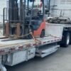 Under-deck toolbox and loading ramp storage on the 2023 Extreme step deck trailer with a forklift on the deck
