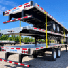 Three Wabash Combo flatbed trailers stacked in a yard, showing aluminum decks, rear lights, wheels and Wabash mud flaps