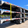 Rear three-quarter view of three stacked Wabash Combo step deck trailers showing aluminum decks, wheels and side rails