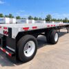 Rear three-quarter view of a Wabash Combo 48 ft flatbed trailer showing the aluminum deck and spread tandem axles